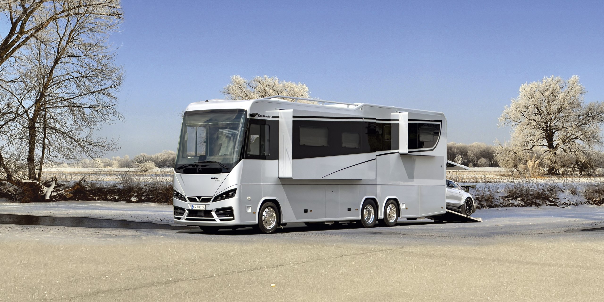 Diese Abbildung zeigt das exklusive und absolut wintertaugliche Reisemobil VARIO Perfect 1200 mit PKW-Garage für Mercedes Benz AMG Roadster in zauberhafter Winterlandschaft.