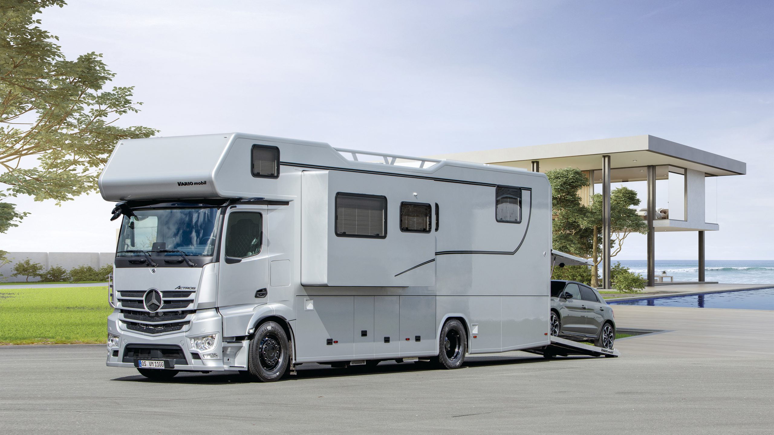 VARIO Alkoven 1050 – Außenaufnahme mit ausgefahrenem Slide Out und PKW-Plattform für Sportsback, am Haus am Meer