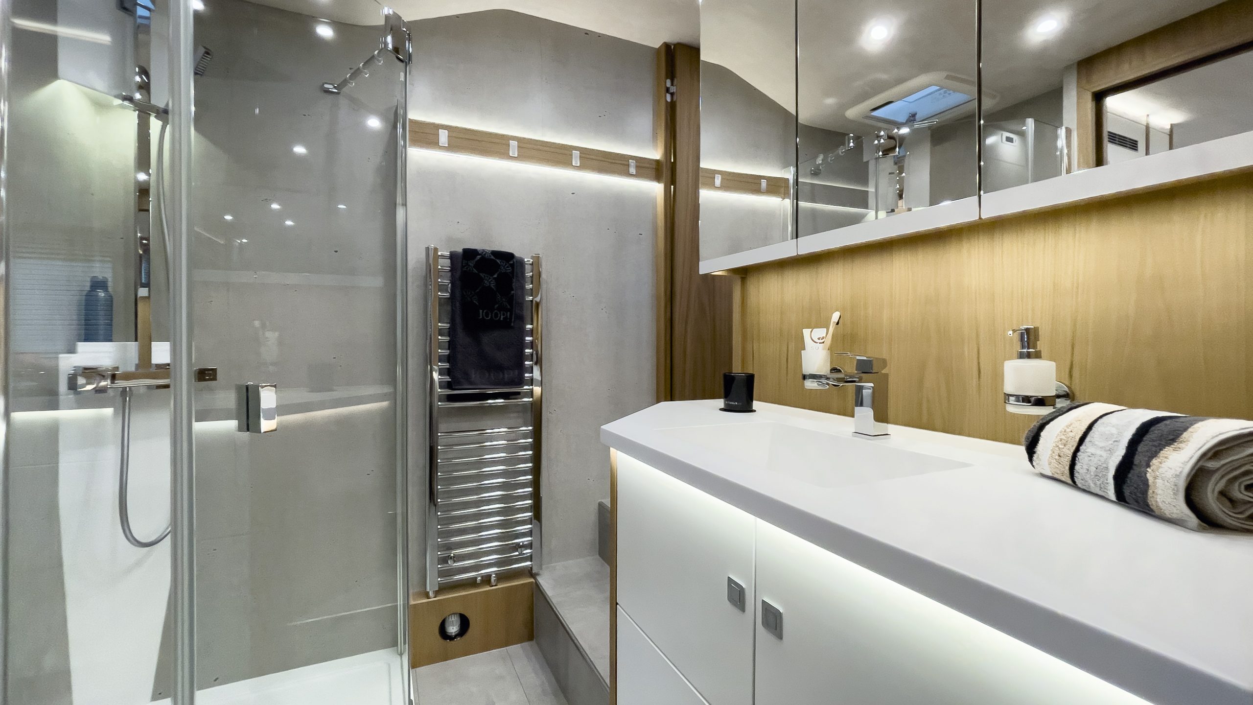 Raumbad im VARIO Alkoven mit Edelholz in Nussbaum hell und Schleiflack-Türen in cremeweiß satiniert