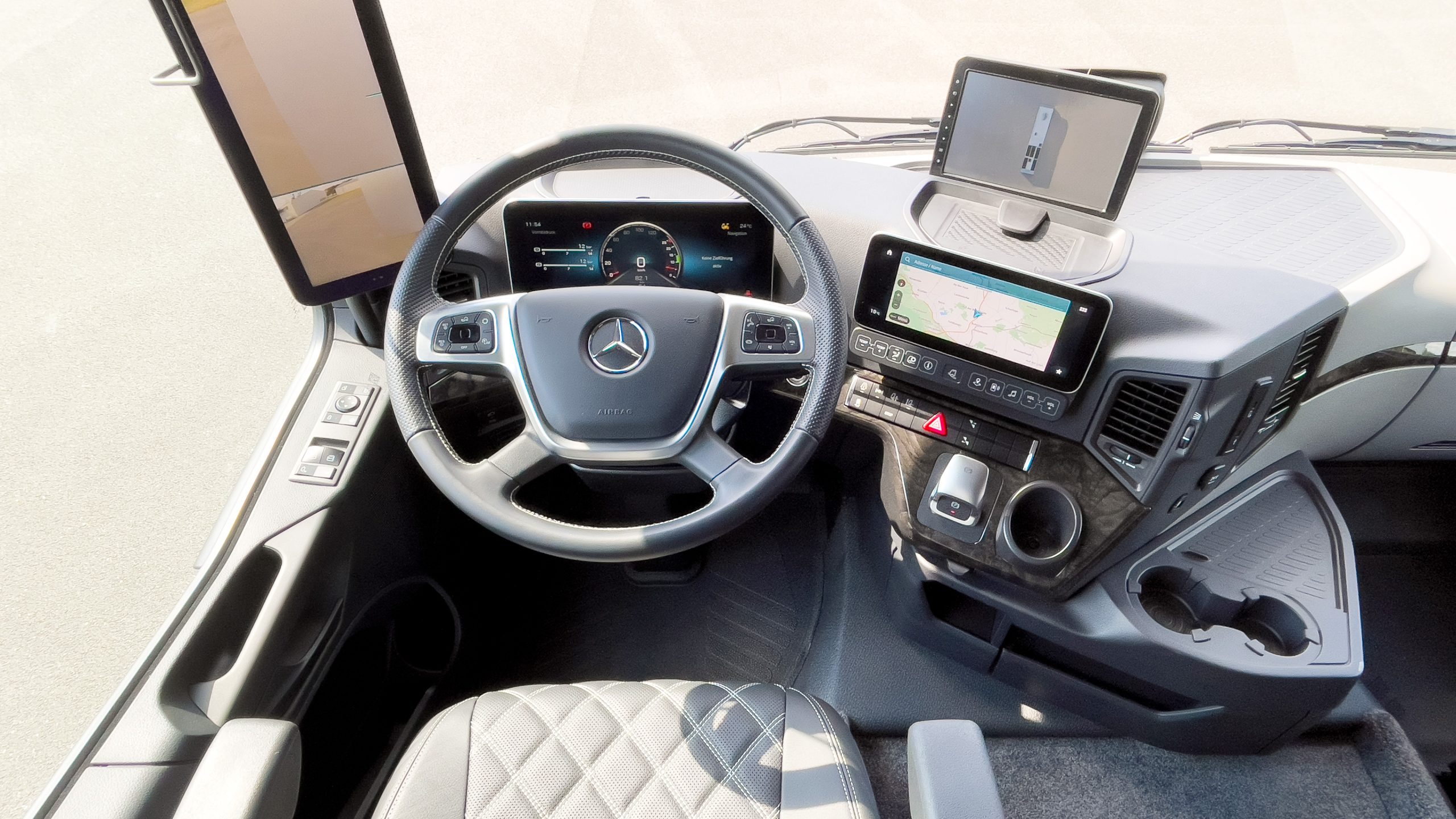 Fahrerplatz im VARIO Alkoven Reisemobil mit Armaturenbrett, Klimasitzen mit Massagefunktion, Actros 1846 HAD Highend und MirrorCom, multiple Fahrerassistenz- und Sicherheitssysteme