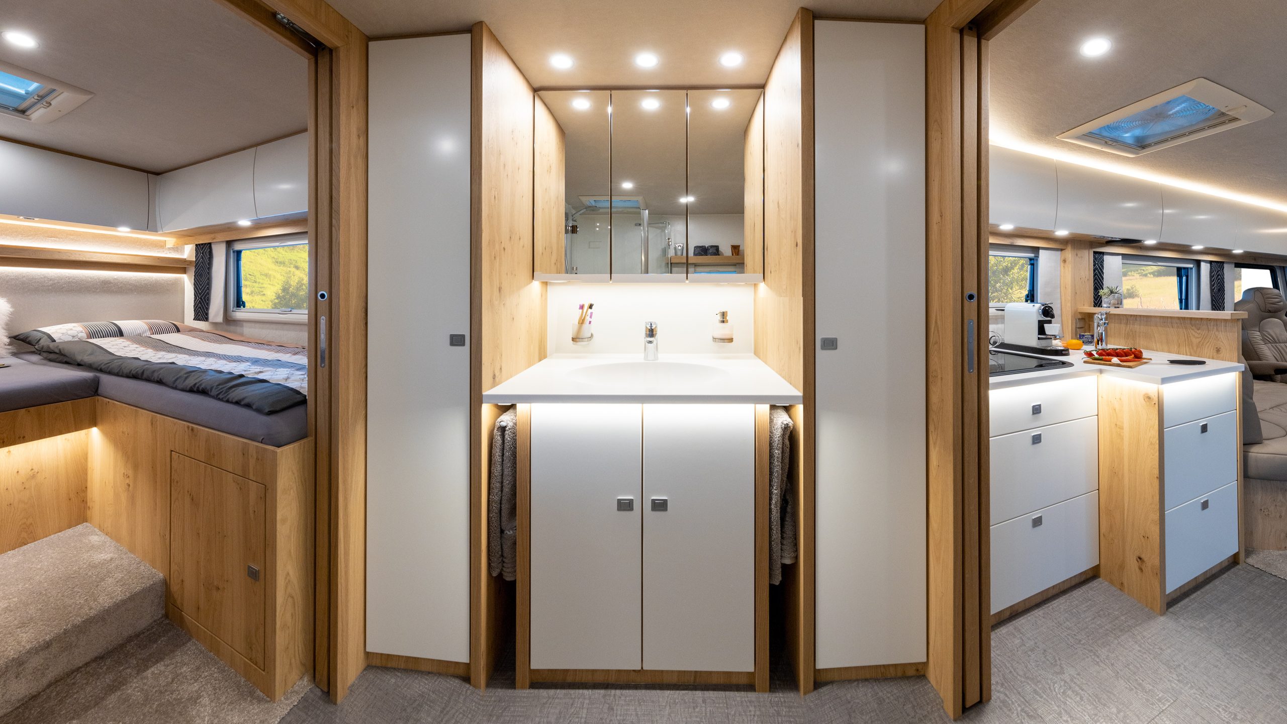 Einzelbetten im Heck, Raumbad, XXL-Waschtisch und L-Küche im VARIO Star – Hochwertiges Interieur in Asteiche Edelholz und Schleiflack weiß satiniert.