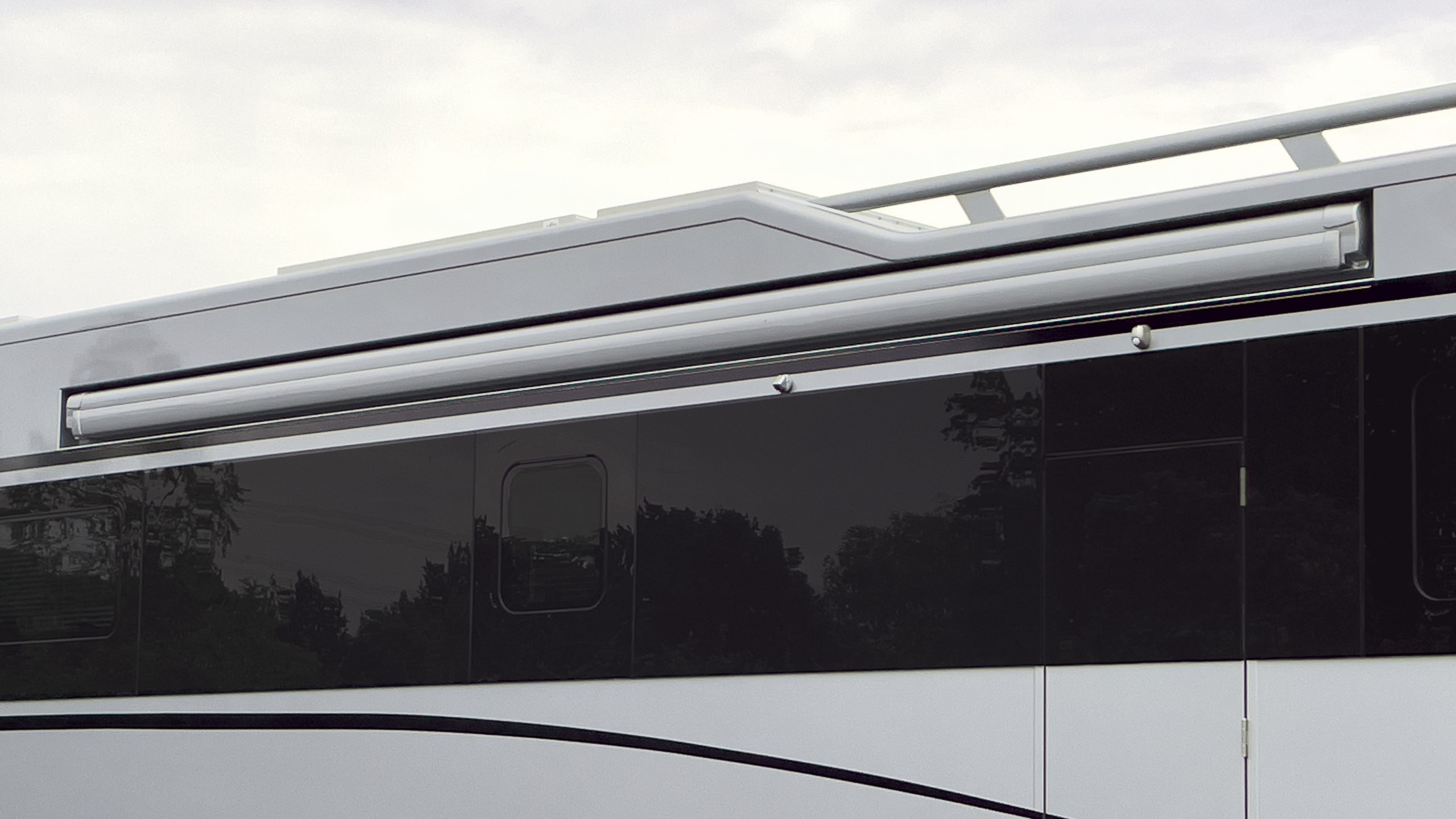 Flächenbündig eingelassene Markise in silber lackiertem Reisemobil mit blackART-Echtglas-Fensterband