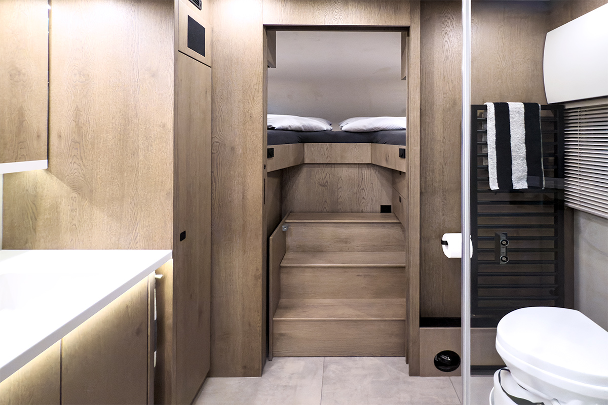 VARIOmobil Alkoven-Reisemobil – Badezimmer mit extrabreiter Ausziehtreppe zum Bett für maximalen Komfort
